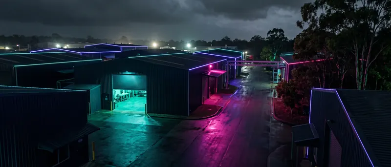 An industrial estate at night with one workshop door glowing